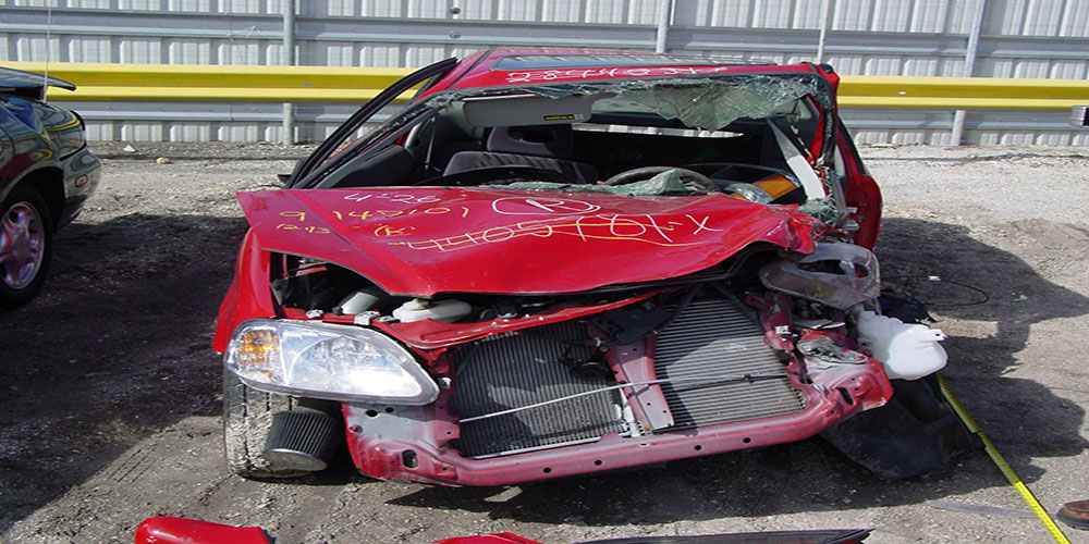 Front-end collision damage on a passenger vehicle documented with investigator's evidence markings