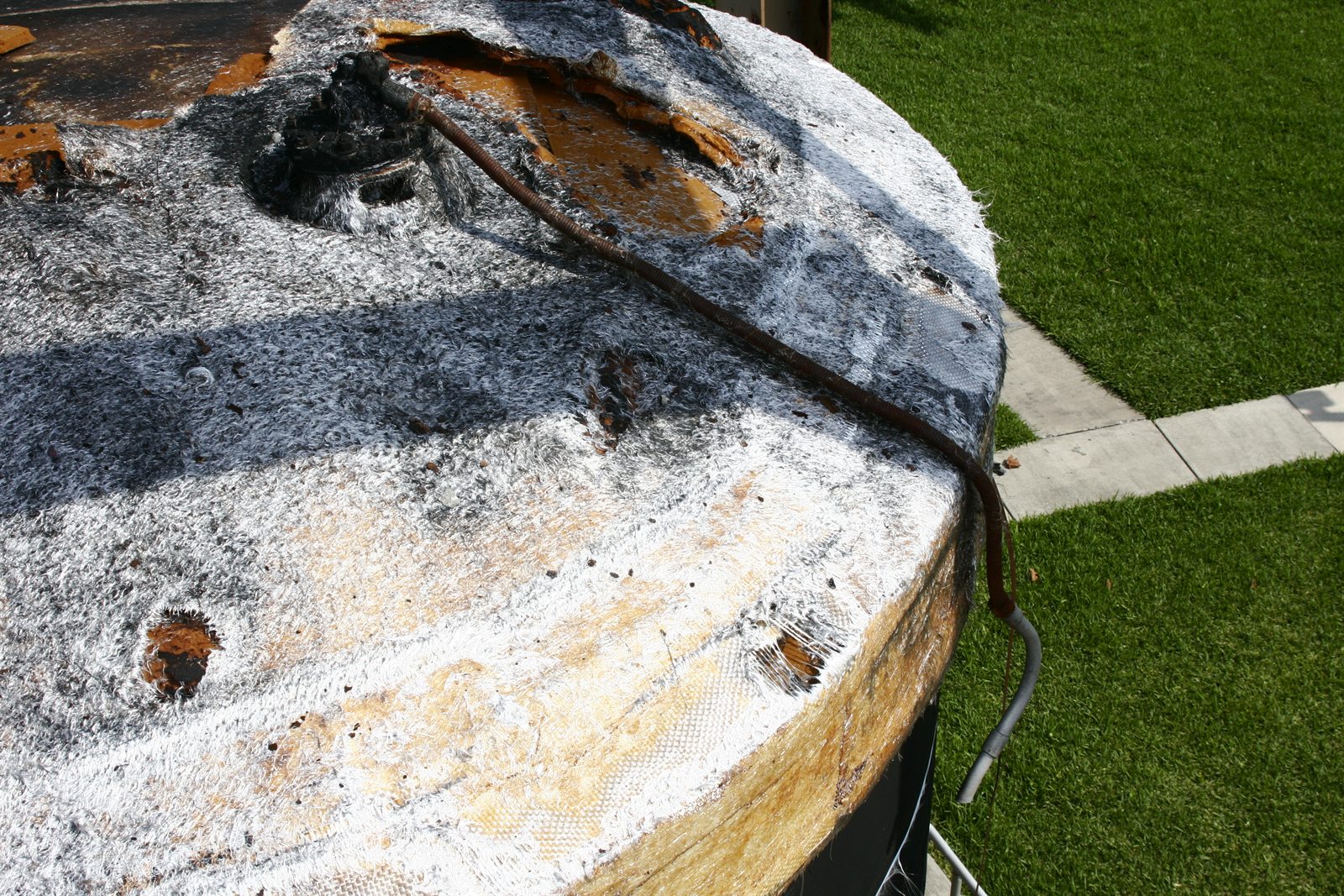 Charred fiberglass tank surface documented during a fire cause and origin investigation